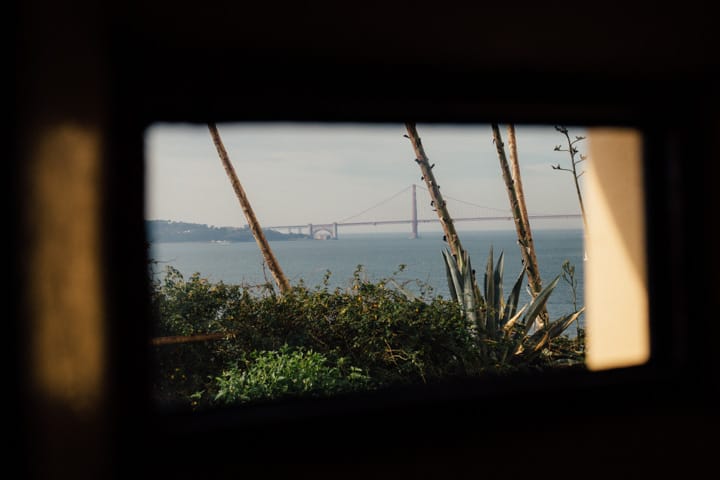 golden gate bridge through small window opening in alcatraz penitentiary