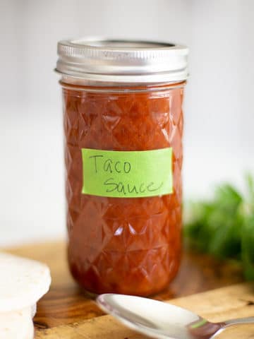 mild taco sauce in a mason jar with flour tortillas and an avocado