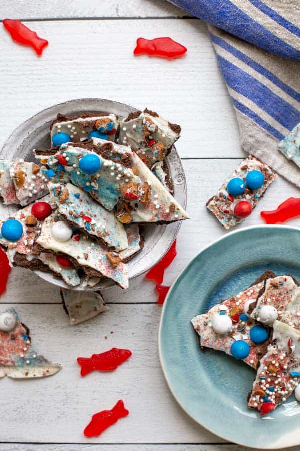 a bowl and plate of white chocolate candy bark with swedish fish