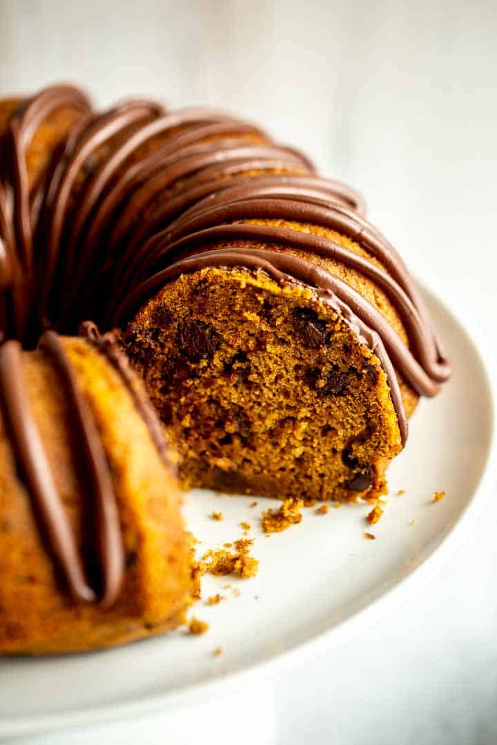 a bundt cake on a cake stand with a slice cut out