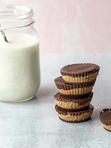 sunbutter cups stacked with a glass of milk in the background