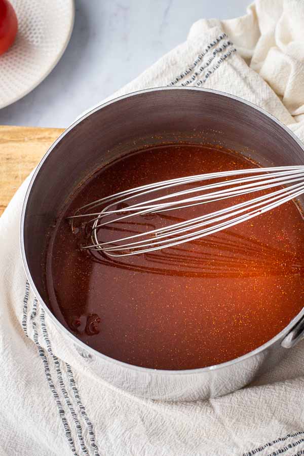 ingredients being whisked in a suacepan