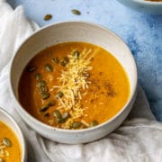 bowl of pumpkin apple soup on a white cloth