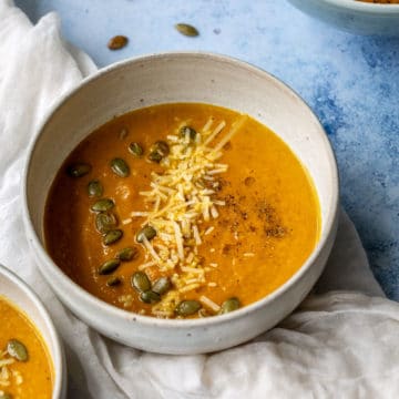 bowl of pumpkin apple soup on a white cloth