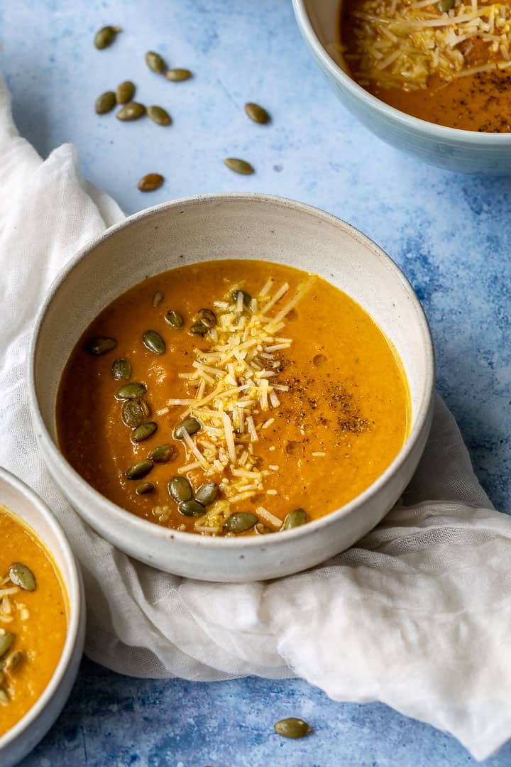 bowl of pumpkin apple soup on a white cloth