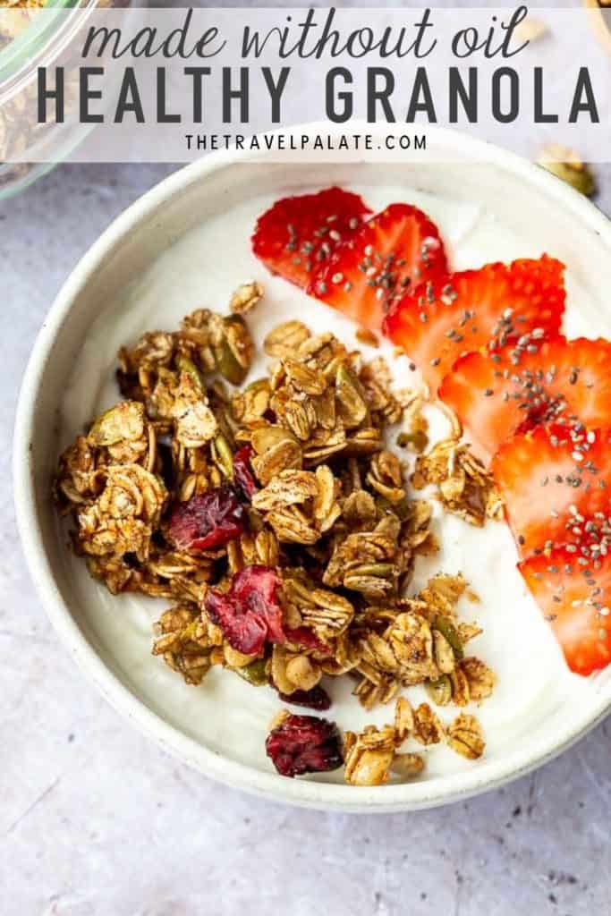 granola and sliced strawberries with yogurt in a white bowl