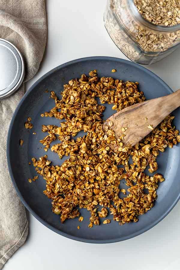 stirring homemade granola after maple syrup was added