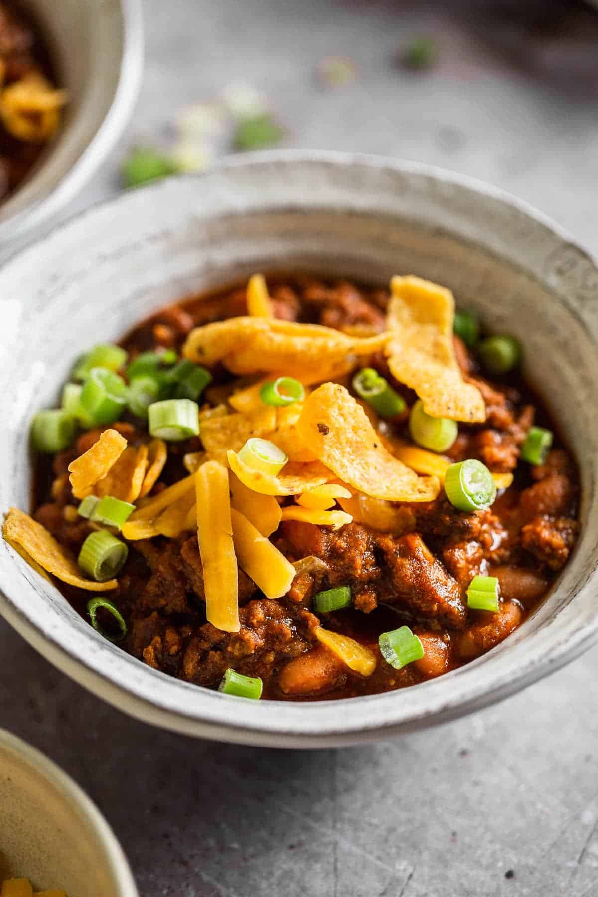 bowl of chili topped with fritos and green onions