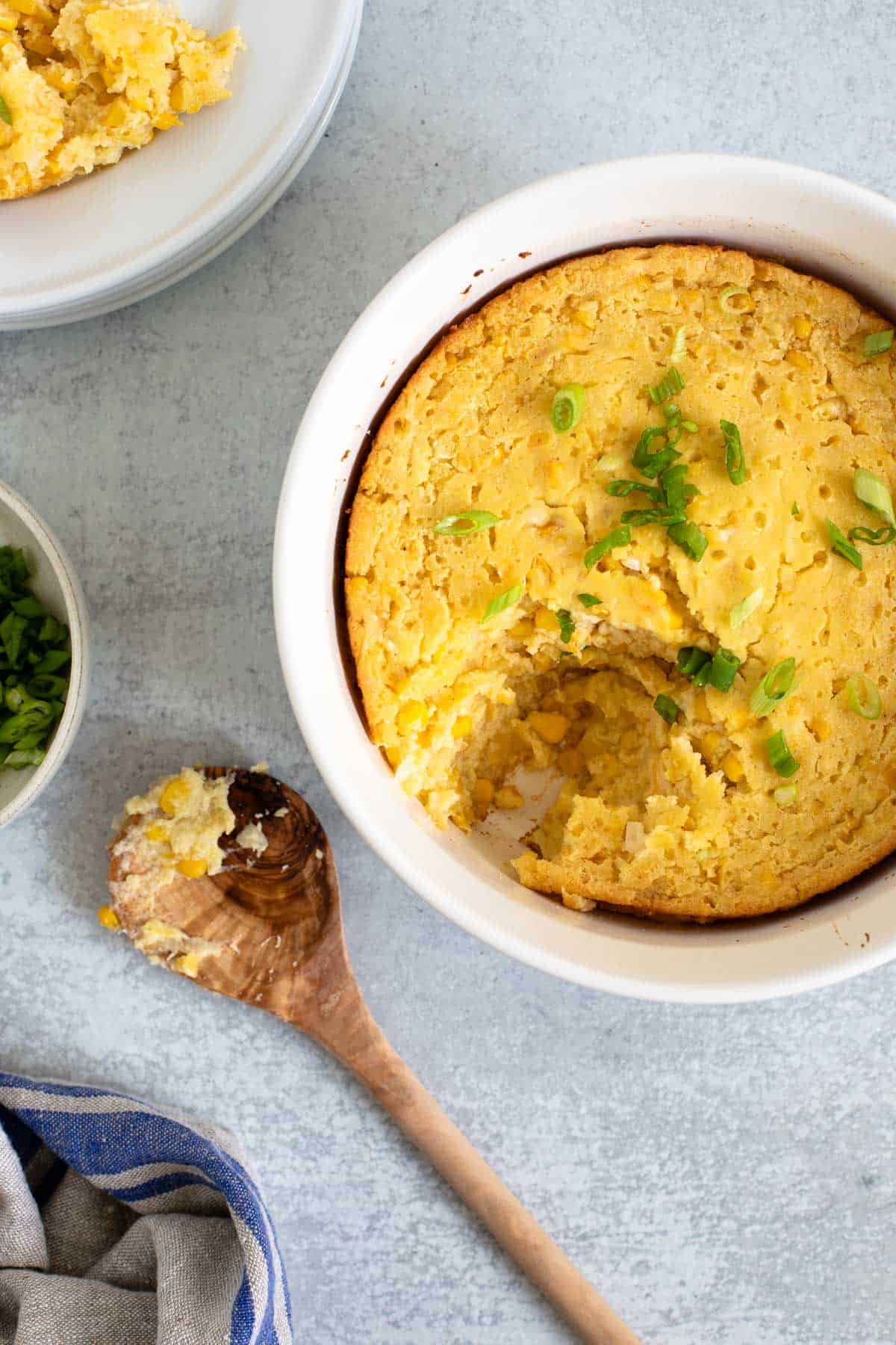 corn casserole with a portions scooped out on a plate in the background