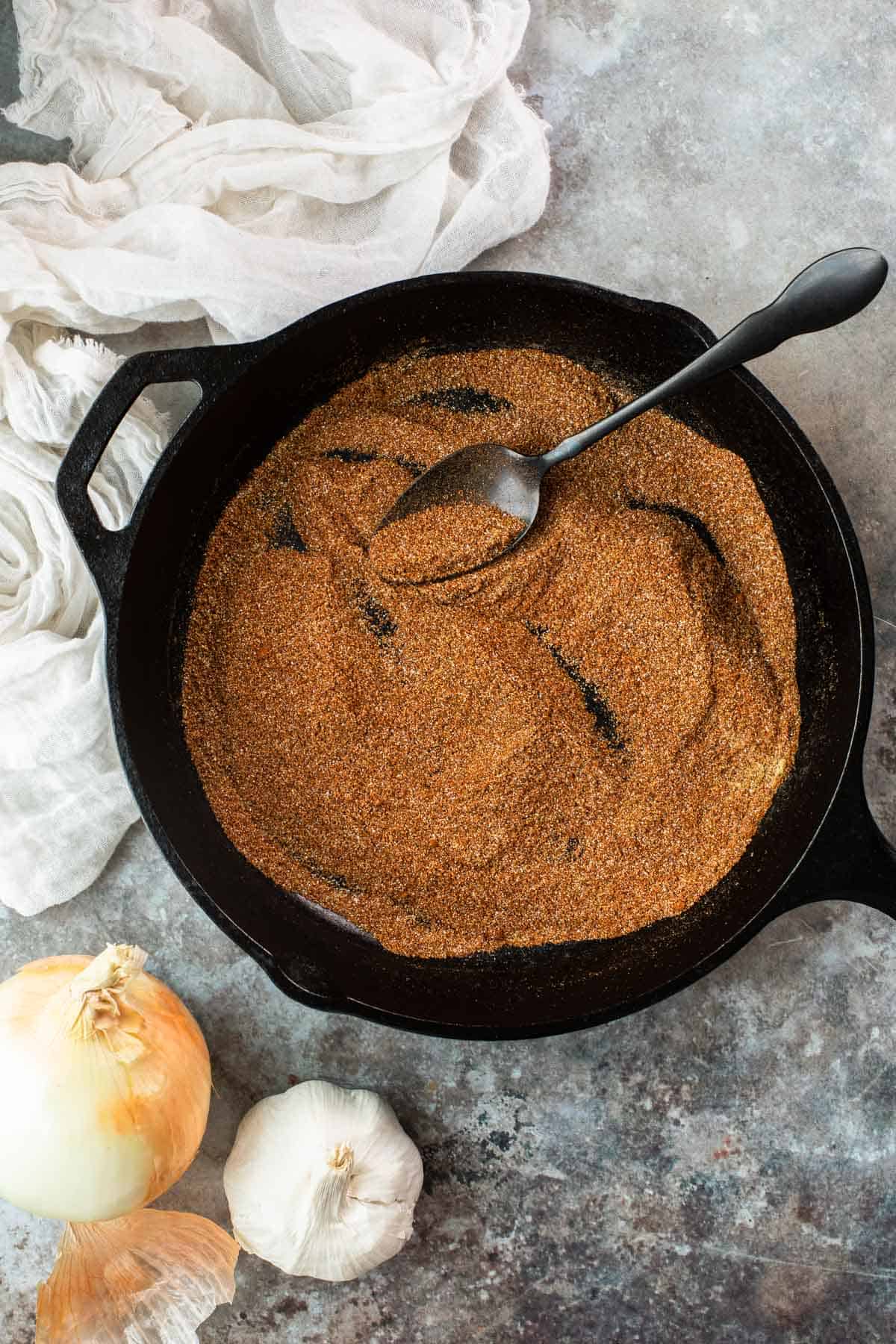 spices being mixed in a cast iron skillet