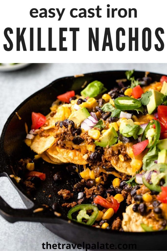 close up view of nachos in a cast iron skillet with text overlay