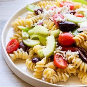 back lighting on a white plate of pasta salad