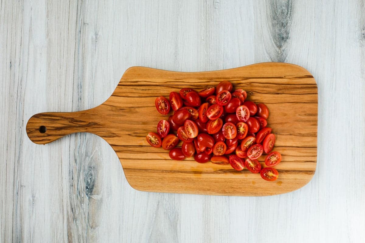 sliced cherry tomatoes on a cutting board