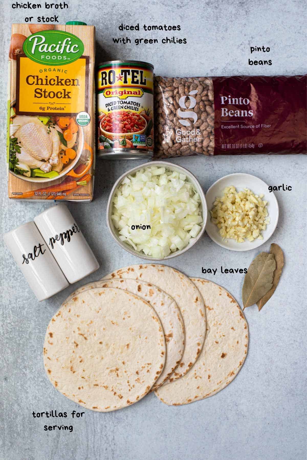 flat lay view of ingredients like chicken broth, chopped onions and garlic