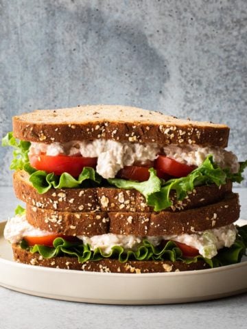 close up of 2 chicken salad sandwiches stacked on a plate