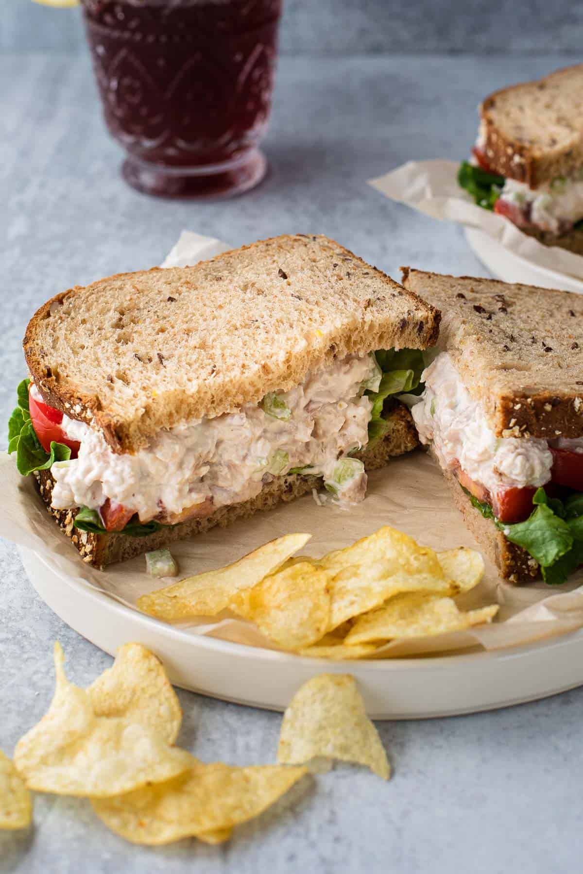 sandwich cut in half with a side of potato chips