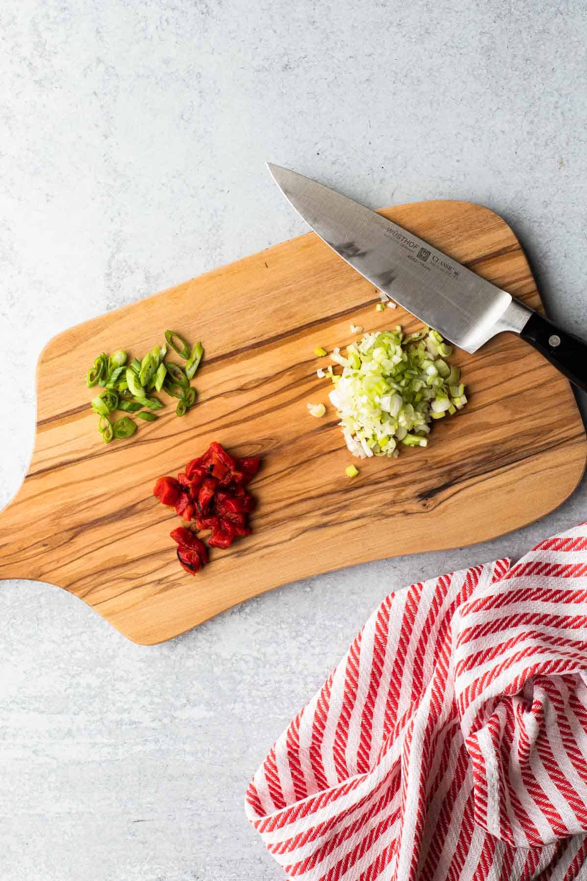 cutting board with chopped peppers and green onion-knife and towel 