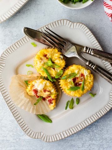 overhead shot of 3 breakfast egg cups on a plate with a fork and knife