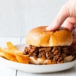 close up of easy sloppy joes with a hand picking up the sandwich