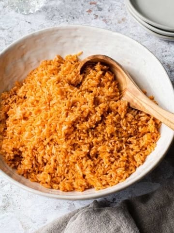 bowl of mexican rice with a wooden spoon