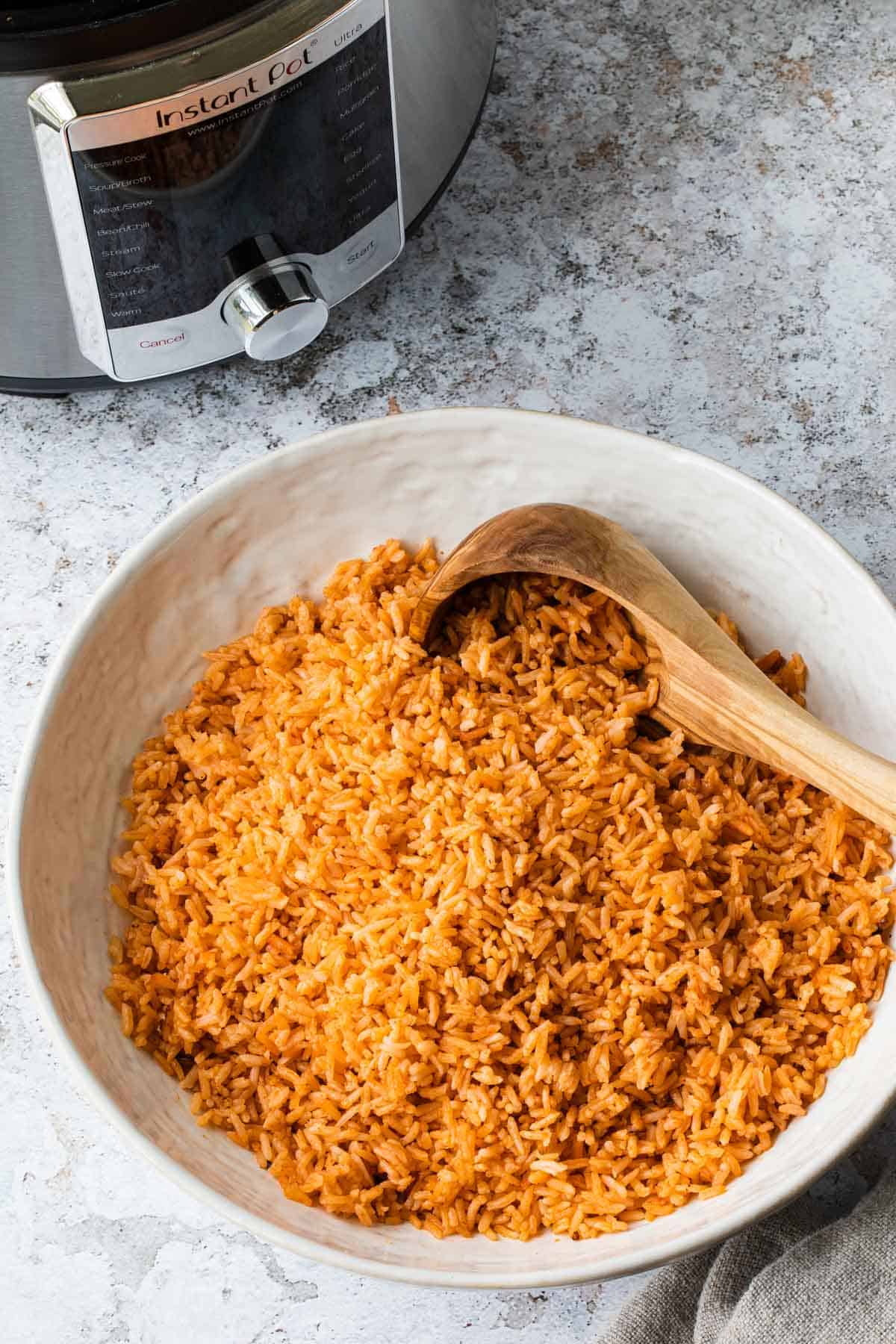 mexican rice in a white bowl with instant pot in the background