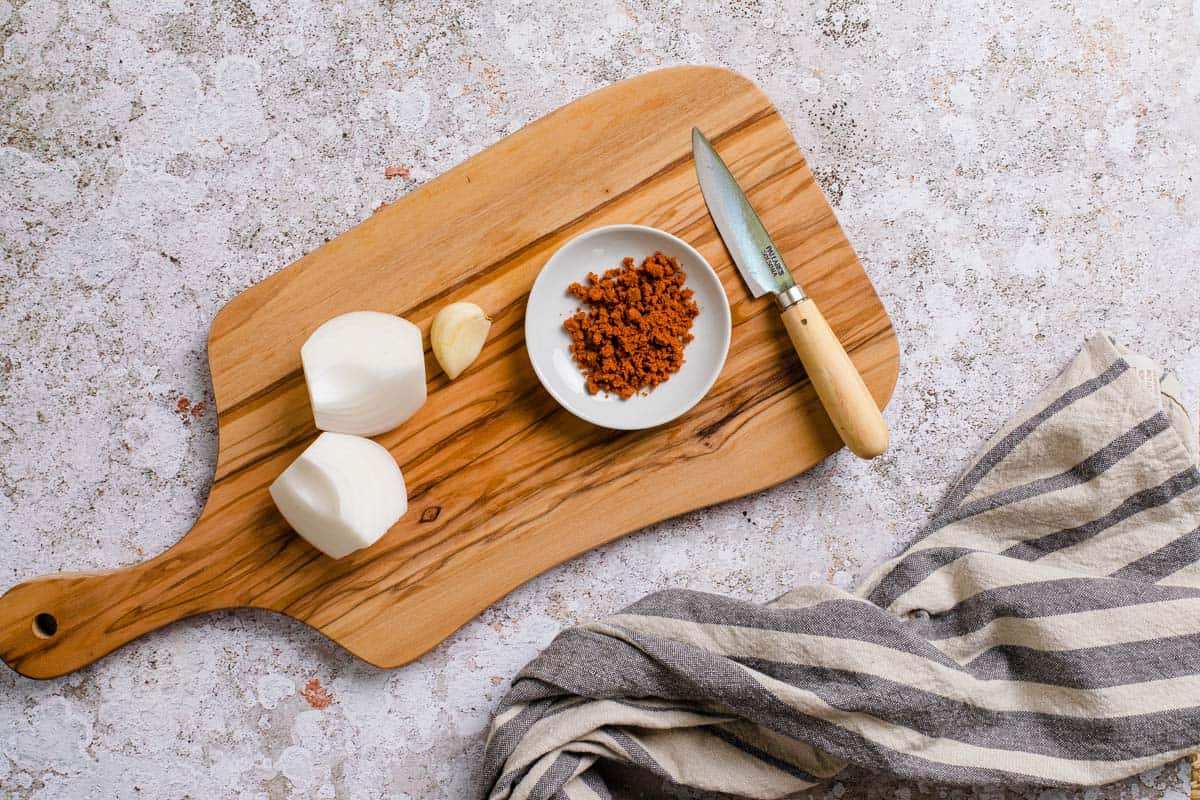 onion, garlic and chopped tomato bouillon on a cutting board