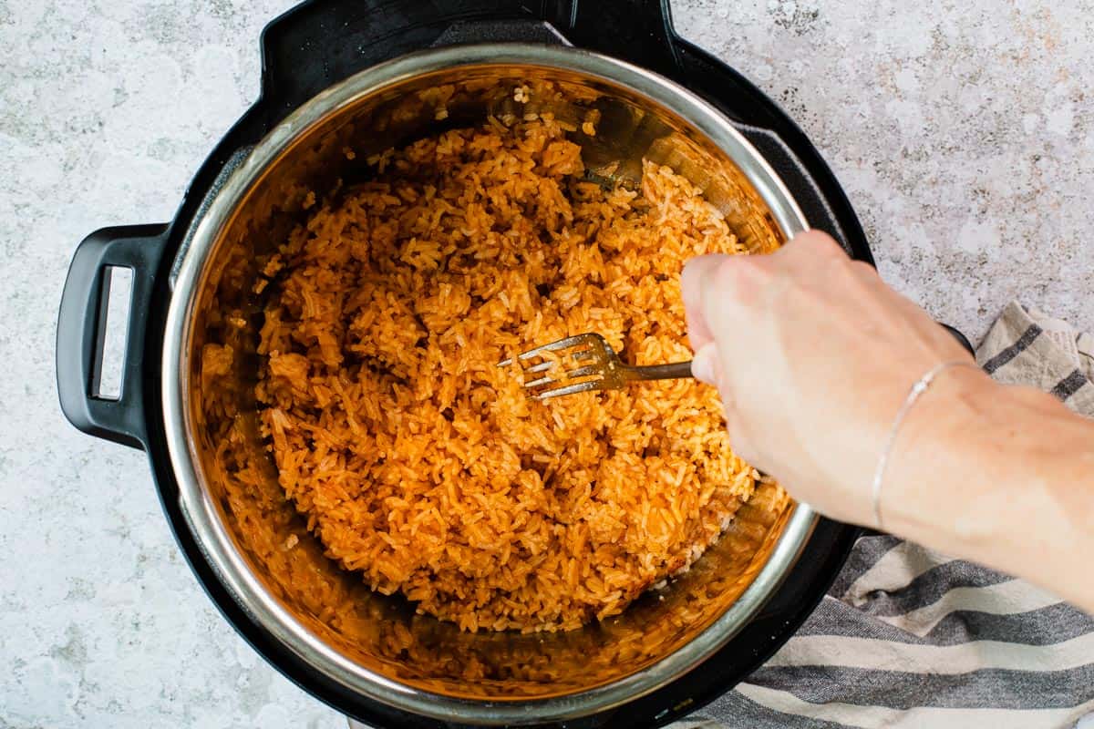 fluffing rice in an instant pot with a fork