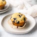 a close up of a blueberry muffin on a white plate