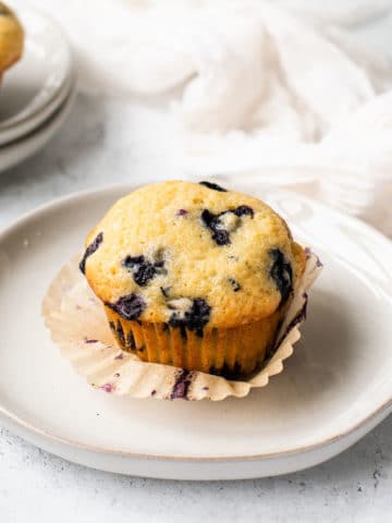 a close up of a blueberry muffin on a white plate