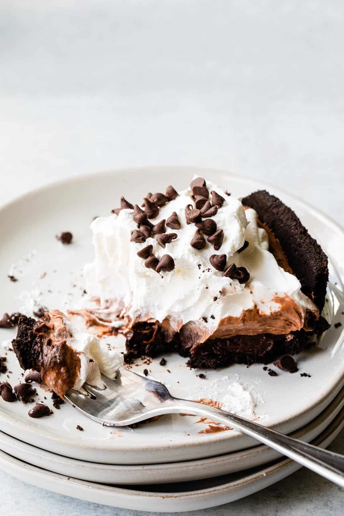 close up view of chocolate pie on a plate with a bite on a fork