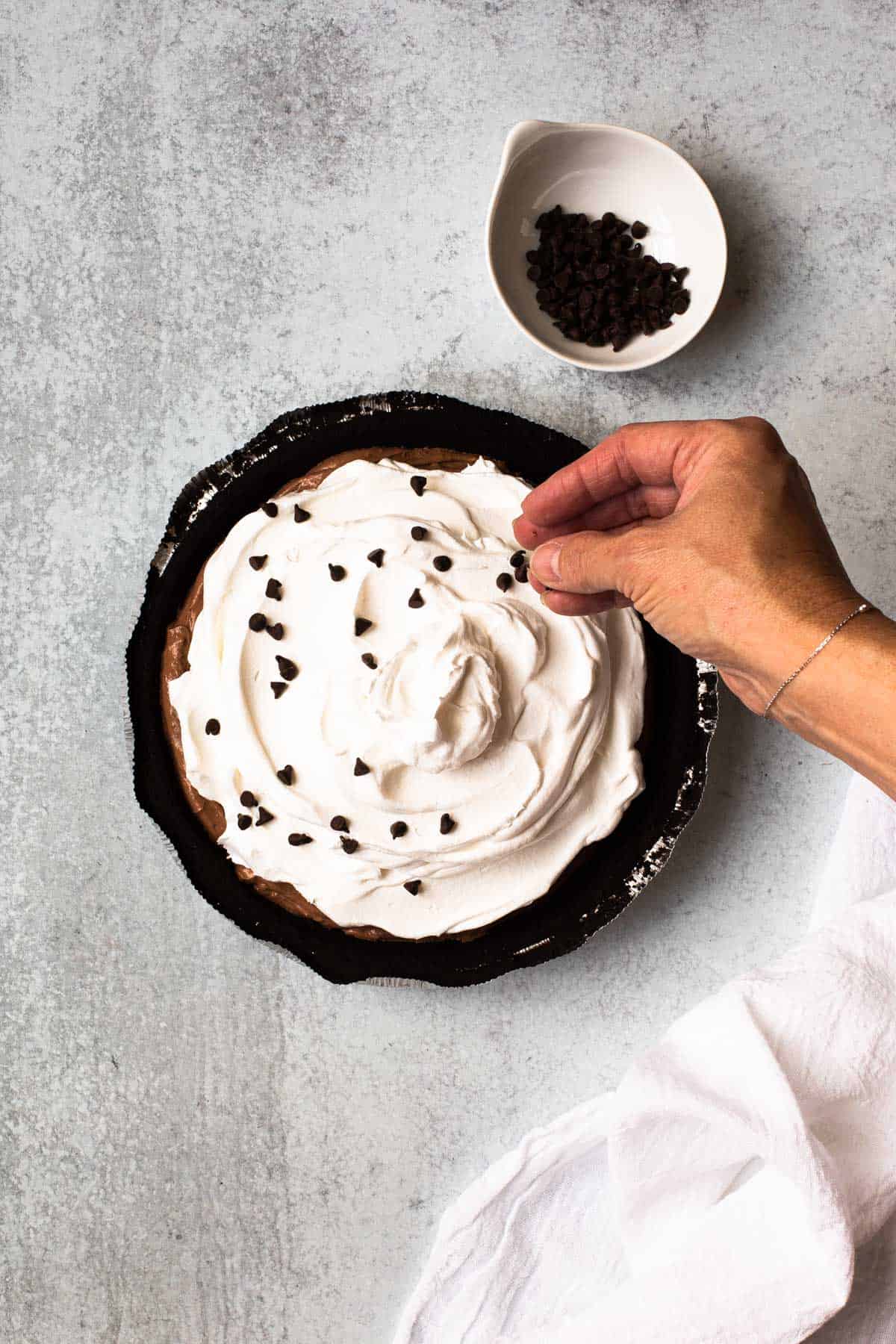 overhead view of adding chocolate chips to finished pie