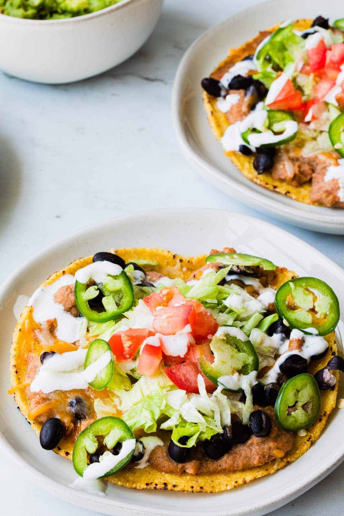 close up of tostada with guacamole in the background