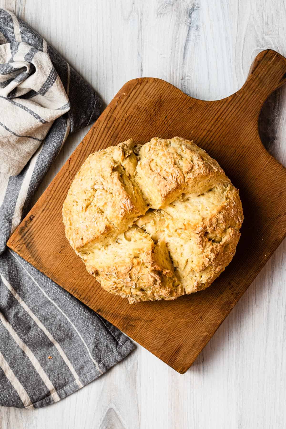 loaf of irish soda bread on a wooden cutting board