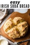 irish soda bread on a wooden cutting board with text overlay for pinterest