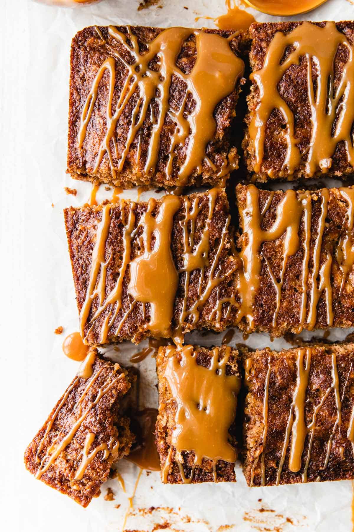 overhead shot of apple spice cake with caramel sauce cut into squares