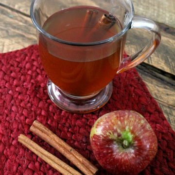 hot drink in a glass with cinnamon sticks on the side