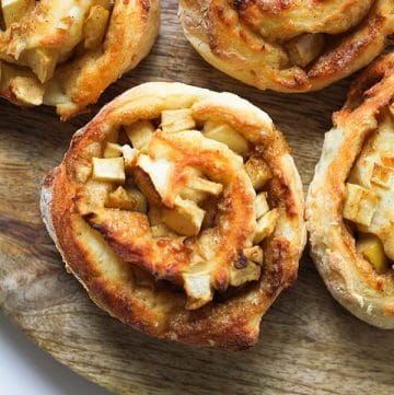 apple cinnamon roll on a wooden serving board.