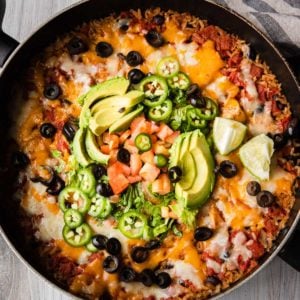 chicken burrito bowl recipe in a skillet with toppings
