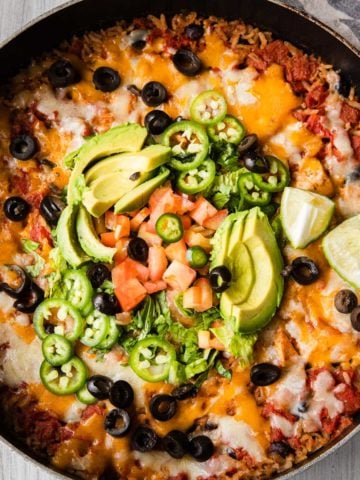 chicken burrito bowl recipe in a skillet with toppings