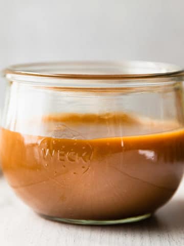 close up straight on view of caramel in a glass jar