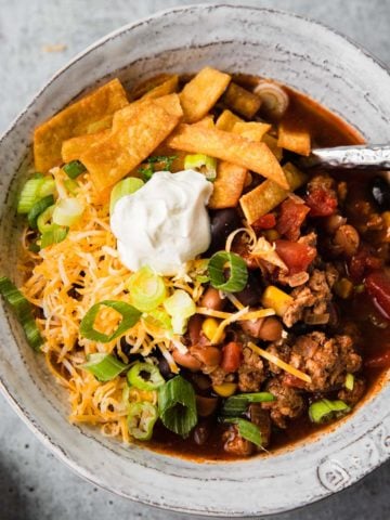 taco soup close up with toppings in a white bowl