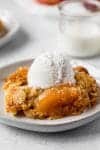 apple dump cake with ice cream on a small plate