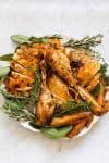 round platter with cut up roasted turkey and fresh herbs