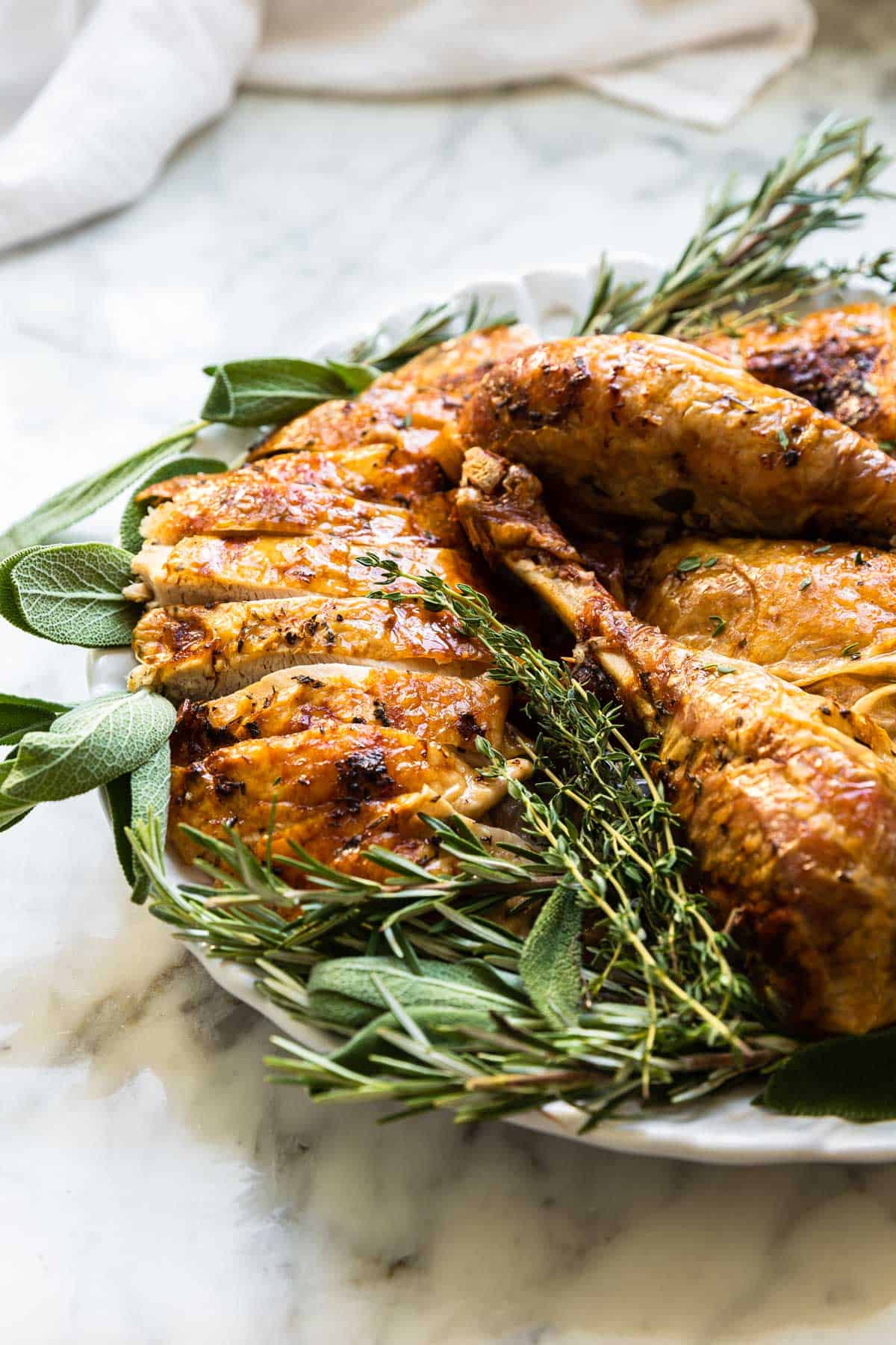 cut up pieces of sliced turkey surrounded by fresh herbs