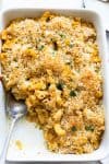 pumpkin mac and cheese in a casserole dish with a portion missing
