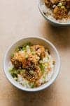 overhead view of teriyaki meatballs in bowl with rice and chopped green onions