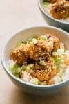 teriyaki meatballs in a bowl with rice and green onions