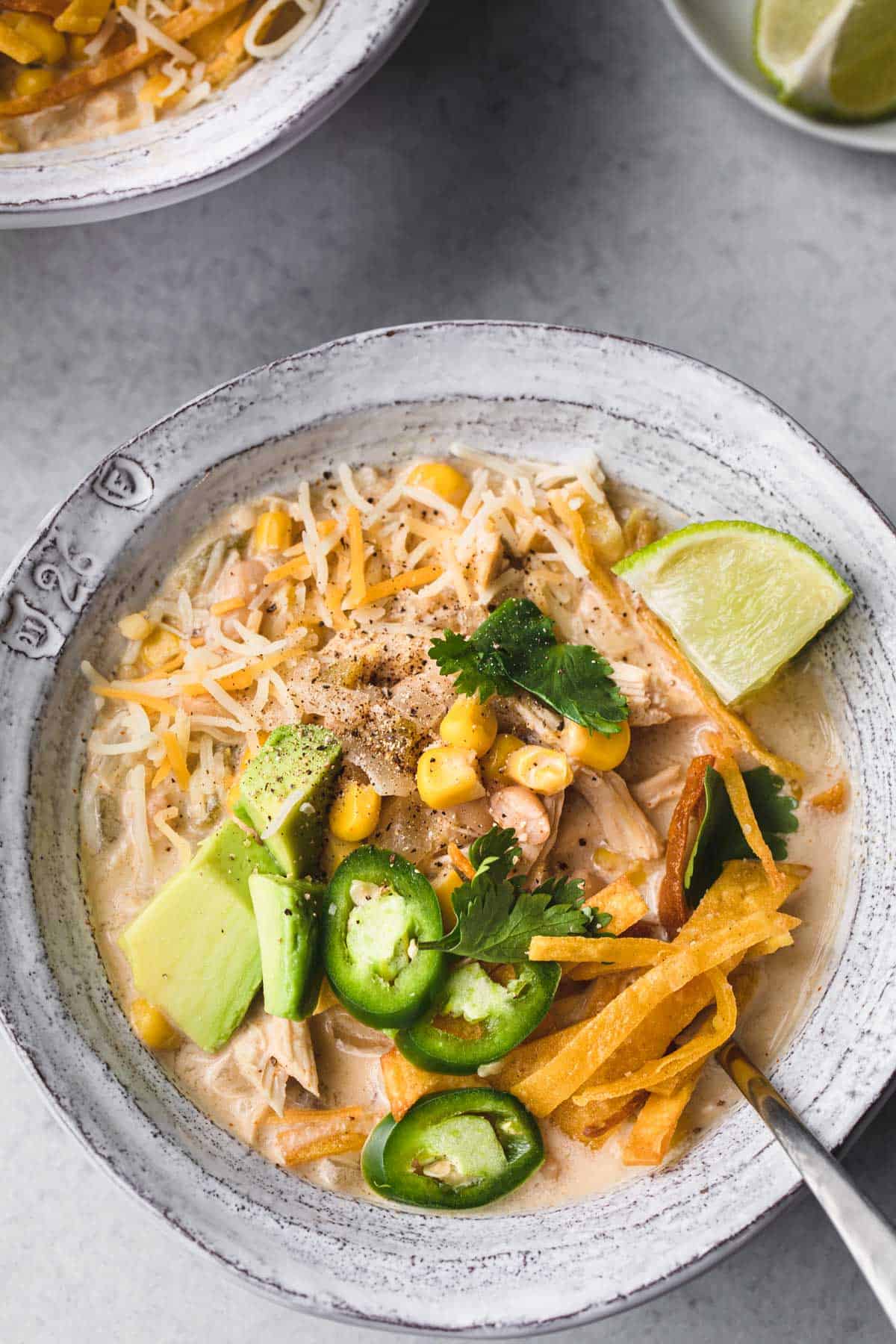 cream cheese chicken chili in a bowl with toppings.