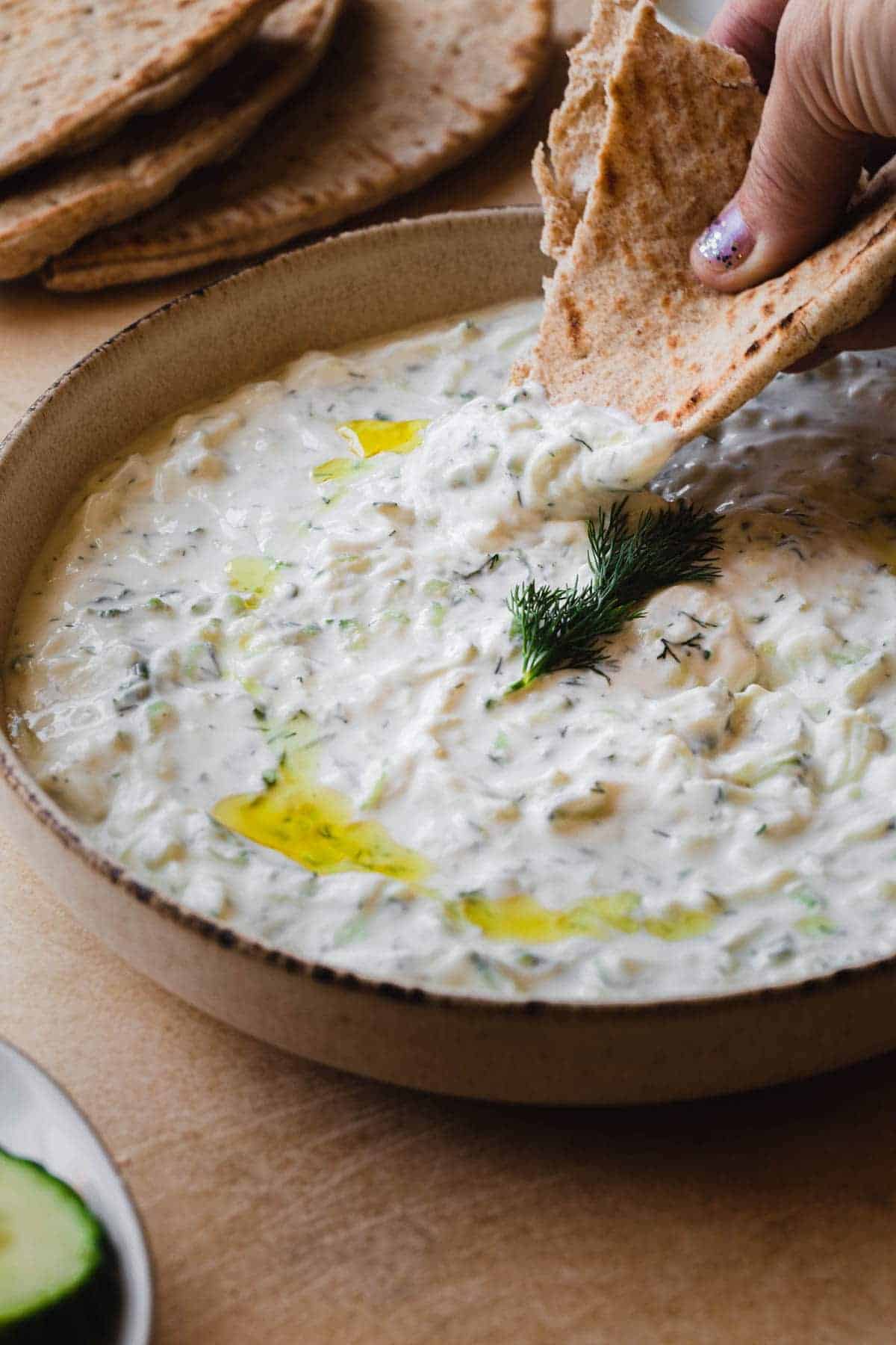 A bow of tzatzik with pita bread.