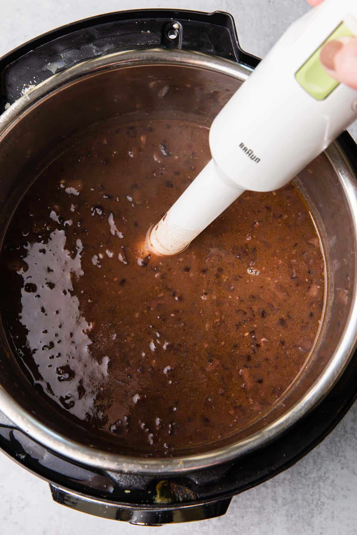 Immersion blender pureeing the soup in the instant pot.